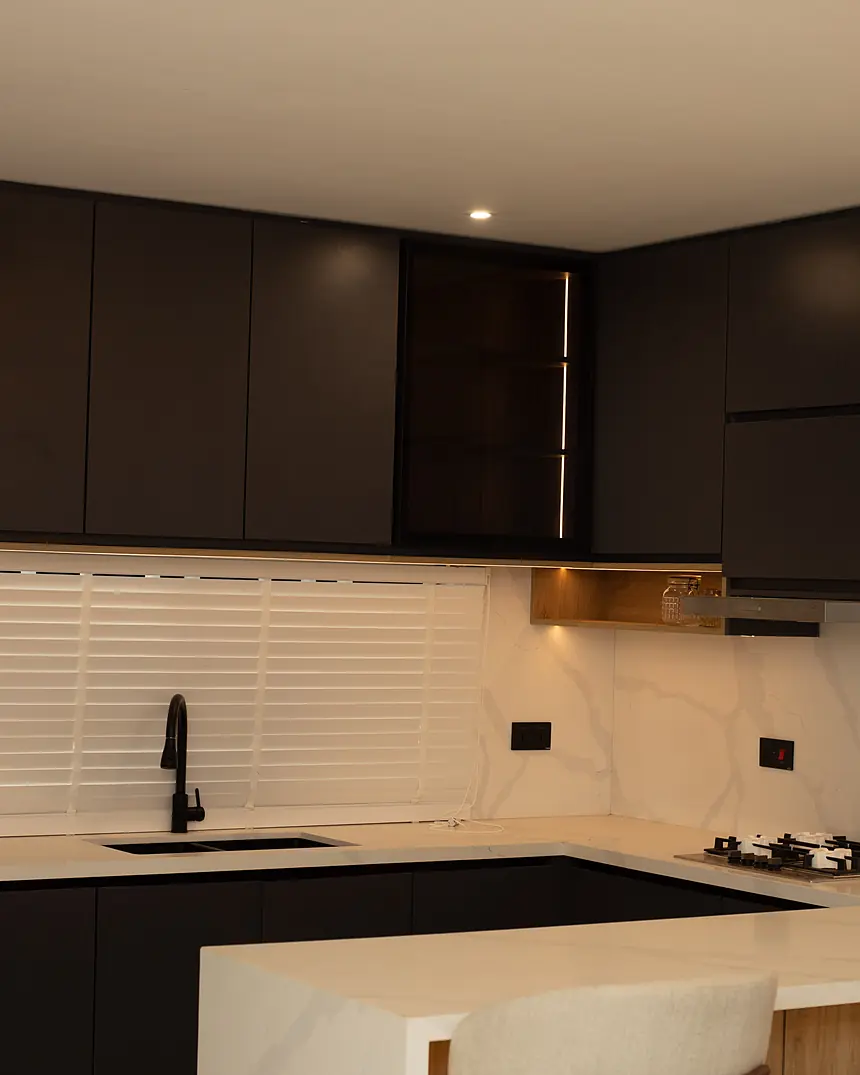 Fitted kitchen with dark cabinetry and stone worktop